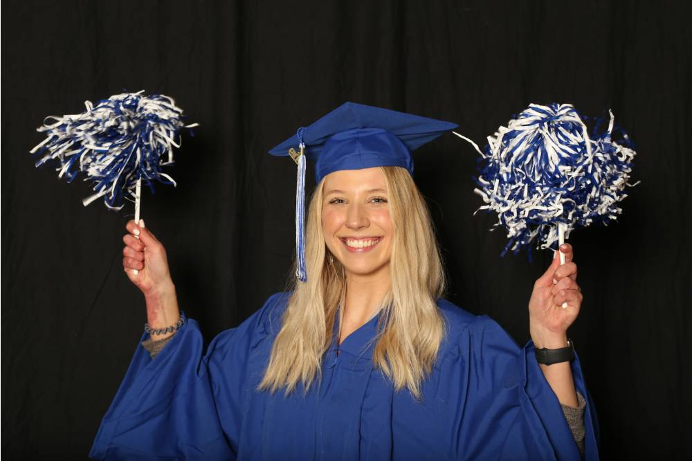 waving pom poms around for a picture at GradFest photo booth